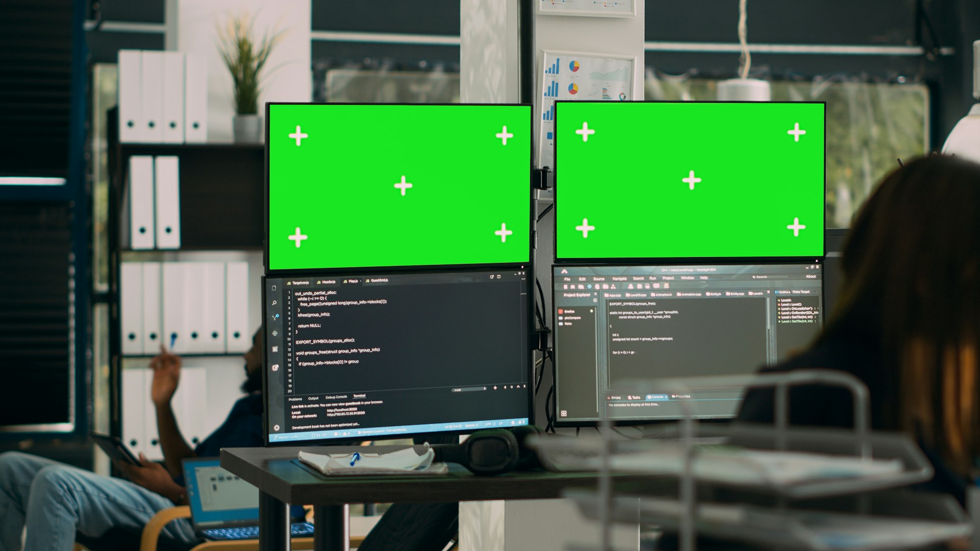 Database developer analyzing greenscreen display on multiple screens